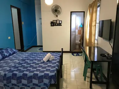 a bedroom with a bed and a table and a desk at Aladino Hostel in Dasmariñas