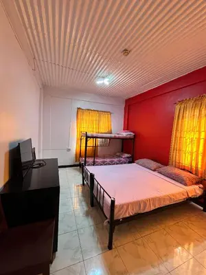 a room with two bunk beds and a desk at Aladino Hostel in Dasmariñas