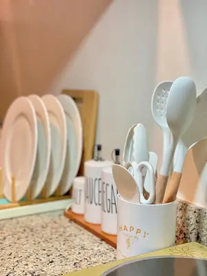 a cup filled with utensils on a kitchen counter at Cozy 1 BR Scandinavian/Tropical Condo with Balcony & Parking in Manila