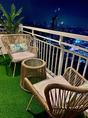 a balcony with two chairs and a table and a chair at Cozy 1 BR Scandinavian/Tropical Condo with Balcony & Parking in Manila