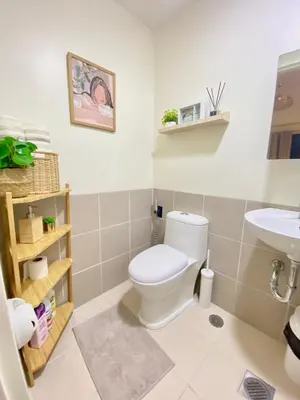 a bathroom with a toilet and a sink at Cozy 1 BR Scandinavian/Tropical Condo with Balcony & Parking in Manila