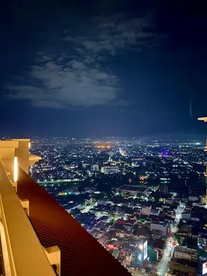 a view of a city at night from an airplane at Cozy 1 BR Scandinavian/Tropical Condo with Balcony & Parking in Manila