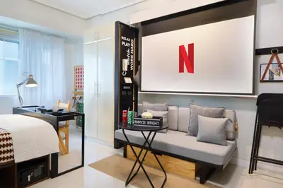 a living room with a couch and a sign on the wall at Relaxing Apt Bgc Business Ready with 84inch Cinema in Manila