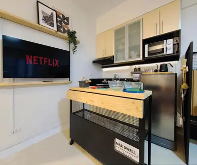 a kitchen with a counter and a refrigerator at Relaxing Apt Bgc Business Ready with 84inch Cinema in Manila