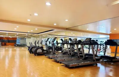 a gym with a row of treadmills at Relaxing Apt Bgc Business Ready with 84inch Cinema in Manila