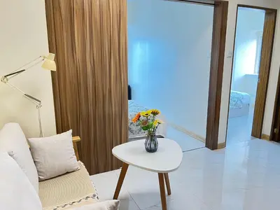 a living room with a vase of flowers on a table at Beachfront U.S. Embassy Family Retreat. in Manila