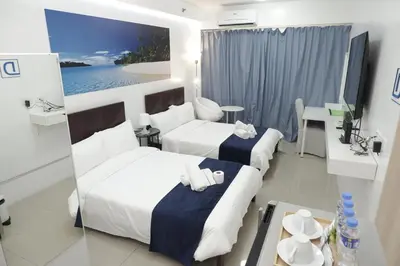 a hotel room with two beds and a table at NAIA Airport 956 DYNASTEL SHORE Staycation in Manila