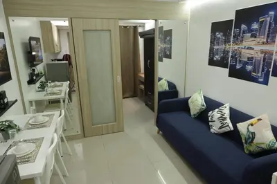 a living room with a blue couch and a table at MOA Arena 1155 CONDOTEL DYNASTEL SHORE in Manila
