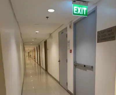 an empty hallway of an office building with an exit sign at MOA Arena 1155 CONDOTEL DYNASTEL SHORE in Manila