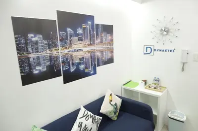 a living room with a blue couch and a picture of a city at MOA Arena 1155 CONDOTEL DYNASTEL SHORE in Manila