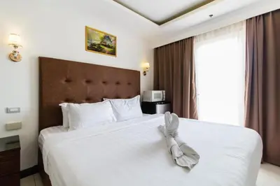 a bedroom with a large white bed with white shoes on it at 60 percent Off Deluxe Ocean View Rooms FREE Pool and FREE Sauna Access Included Perfect Location Near US Embassy, NAIA, Makati, BGC, Mall of Asia, and Chinatown Dont Miss Out Book Now and Save Updated Price 2025 in Manila