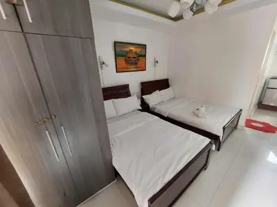 two twin beds in a room with a closet at 60 percent Off Deluxe Ocean View Rooms FREE Pool and FREE Sauna Access Included Perfect Location Near US Embassy, NAIA, Makati, BGC, Mall of Asia, and Chinatown Dont Miss Out Book Now and Save Updated Price 2025 in Manila