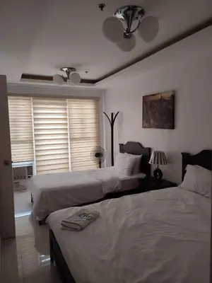 a bedroom with two beds and two windows at 60 percent Off Deluxe Ocean View Rooms FREE Pool and FREE Sauna Access Included Perfect Location Near US Embassy, NAIA, Makati, BGC, Mall of Asia, and Chinatown Dont Miss Out Book Now and Save Updated Price 2025 in Manila