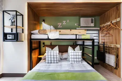 a bunk bed in a room with a bed in a room at Spacious Family Sleeper BGC & 84inch Cinema in Manila
