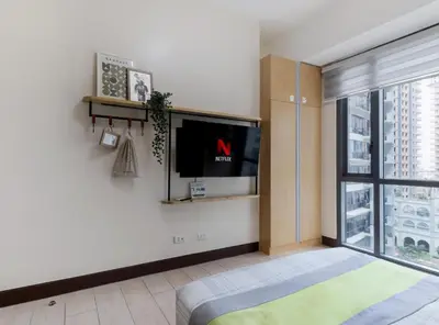a living room with a tv and a large window at Spacious Family Sleeper BGC & 84inch Cinema in Manila