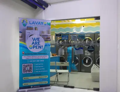 a sign in front of a laundry room with machines at Spacious Family Sleeper BGC & 84inch Cinema in Manila