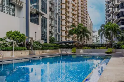 a swimming pool in a city with tall buildings at Spacious Family Sleeper BGC & 84inch Cinema in Manila