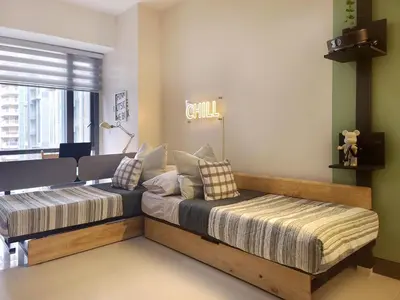 a bedroom with two beds with pillows on it at Spacious Family Sleeper BGC & 84inch Cinema in Manila