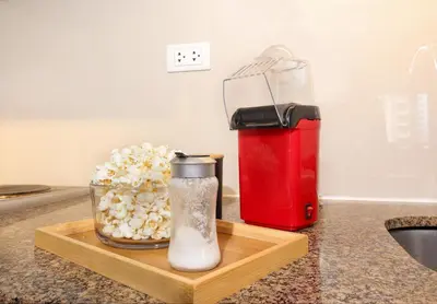 a container of popcorn next to a red appliance on a counter at Max Dwell Bgc Creative Space with 84 