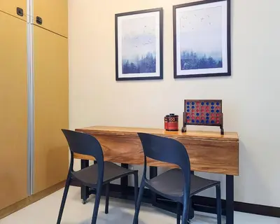 a dining room with a wooden table and chairs at Max Dwell Bgc Creative Space with 84 