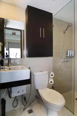 a bathroom with a toilet and a sink and a shower at Max Dwell Bgc Creative Space with 84 