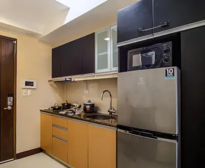 a kitchen with a stainless steel refrigerator and cabinets at Max Dwell Bgc Creative Space with 84 