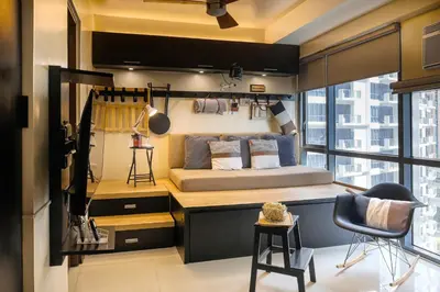 a bedroom with a bed and a chair in a room at Max Dwell Bgc Creative Space with 84 