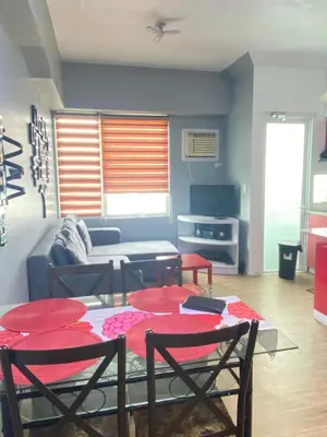 a living room with a table and chairs and a couch at Staycation bigger room in Manila