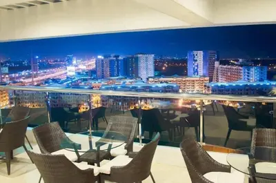 a restaurant with a view of a city at night at Staycation bigger room in Manila