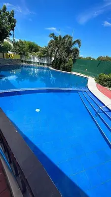 a large swimming pool with blue water at Staycation bigger room in Manila
