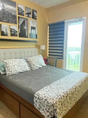 a bed in a bedroom with a window and a bedvisor at Staycation bigger room in Manila