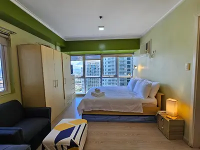 a bedroom with a bed and a large window at South of Market near High Street BGC Classy & Stylish Studio, central location with city view in Manila