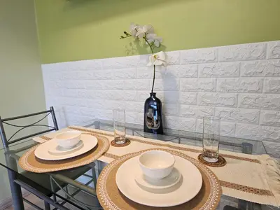 a table with two plates and a vase with flowers at South of Market near High Street BGC Classy & Stylish Studio, central location with city view in Manila