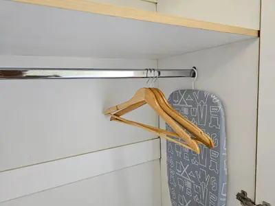 a closet with a wooden hanger and a surfboard at South of Market near High Street BGC Classy & Stylish Studio, central location with city view in Manila