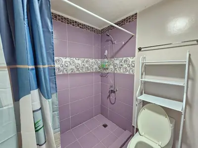 a purple bathroom with a toilet and a shower at South of Market near High Street BGC Classy & Stylish Studio, central location with city view in Manila