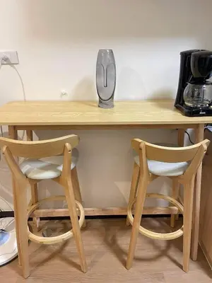 a wooden table with two chairs and a coffee maker on it at Brand new condo for travelers in Paranaque near airport in Manila