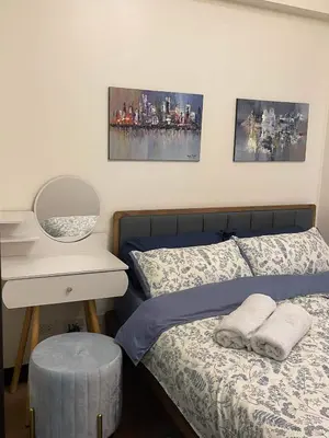 a bedroom with a bed with a nightstand and a bed sidx sidx sidx sidx at Brand new condo for travelers in Paranaque near airport in Manila