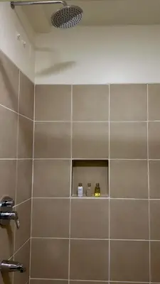 a bathroom with a shower with a tile wall at Brand new condo for travelers in Paranaque near airport in Manila