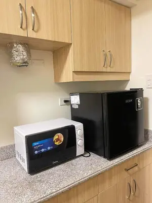 a microwave and a toaster oven on a kitchen counter at Brand new condo for travelers in Paranaque near airport in Manila