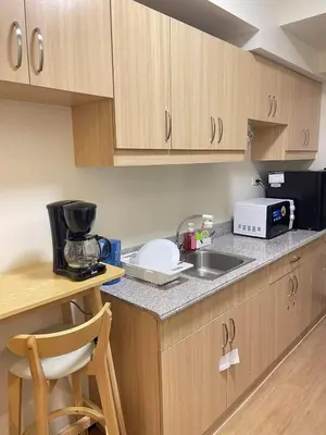a kitchen with a sink and a microwave at Brand new condo for travelers in Paranaque near airport in Manila