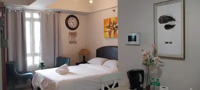 a bedroom with a bed and a clock on the wall at Alps at 150 Newport Blvd Condominum near T3 in Manila