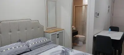 a bedroom with a bed and a bathroom with a toilet at Alps at 150 Newport Blvd Condominum near T3 in Manila