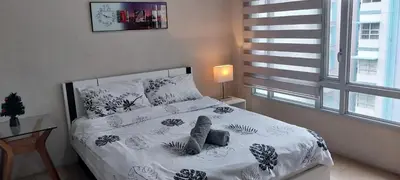 a bedroom with a bed with white sheets and a window at Alps at 150 Newport Blvd Condominum near T3 in Manila