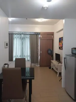 a living room with a bed and a table and a couch at Alps at 150 Newport Blvd Condominum near T3 in Manila