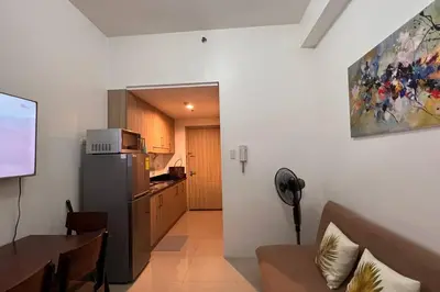 a kitchen and dining room with a refrigerator and a table at Direct Pool Access Shore Residences MOA Pasay Near Airport in Manila
