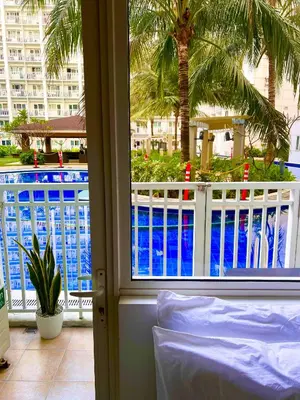 a view of a pool from a hotel room window at Direct Pool Access Shore Residences MOA Pasay Near Airport in Manila
