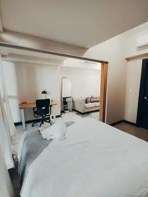 a bedroom with a large white bed and a desk at Perfect for Working, Quiet & Relaxing at Uptown BGC in Manila