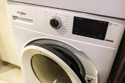 a white washing machine in a room at Spacious 2BR Apartment in BGC with Workspace & Washer in Manila