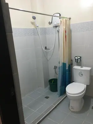 a bathroom with a toilet and a shower at AGB Anchorage Inn, studio room - 2 single beds in Manila