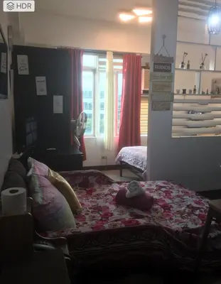 a bedroom with a bed with a teddy bear on it at Cozy Starpad14R Stamford McKinley Hill in Manila